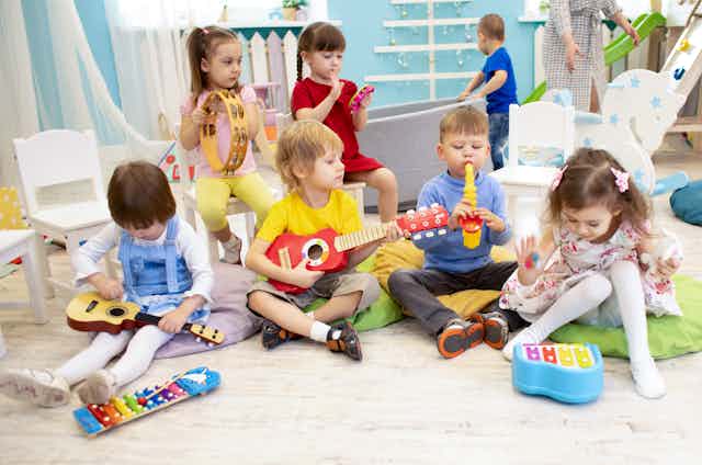 Un grupo de niños pequeños toca instrumentos en clase