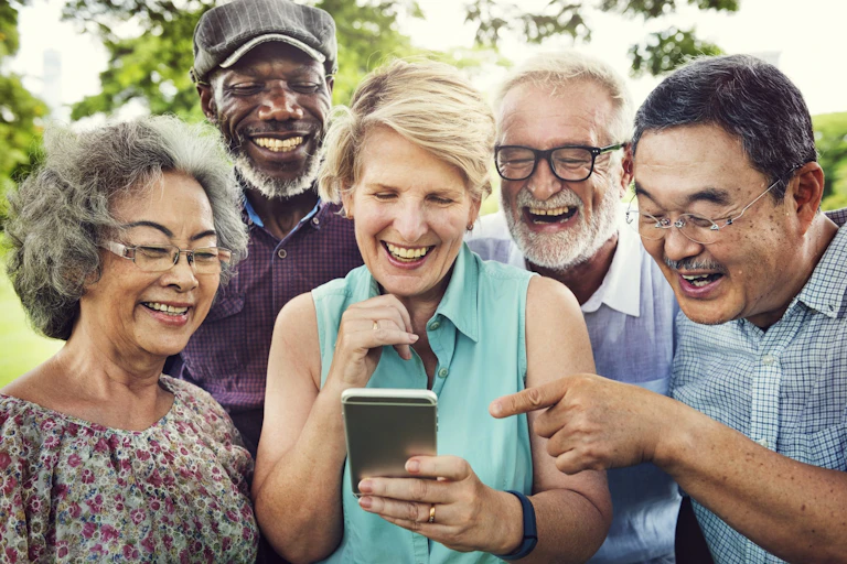 personnes âgées regardent un écran de cellulaire