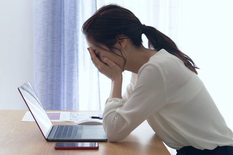 Woman looks distraught will sitting at desk