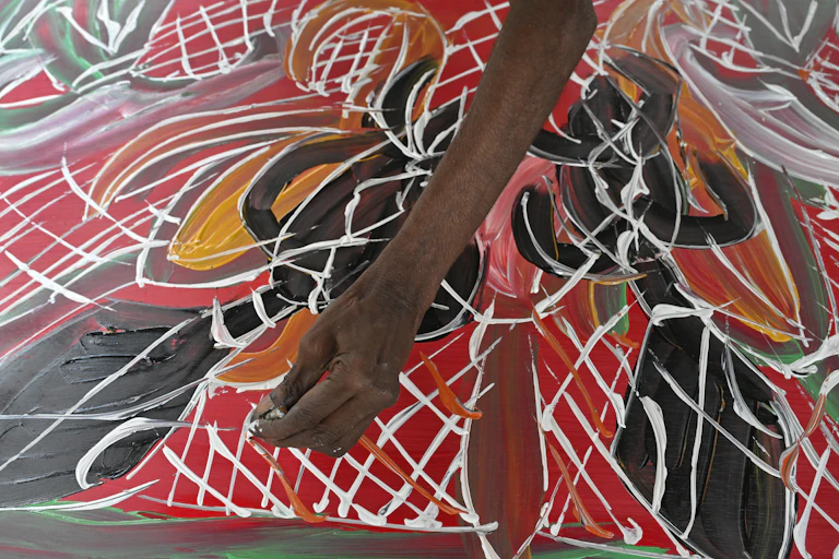 Yolngu artist Dhambit Mununngurr works on a painting during the 2023 Garma Festival.