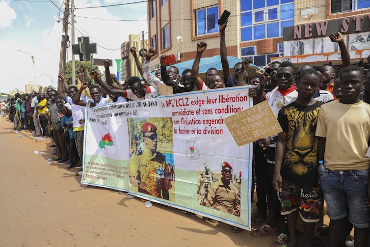 People on the streets of Burkina Faso demonstrating in support of the military coup and carrying anti-French placards.