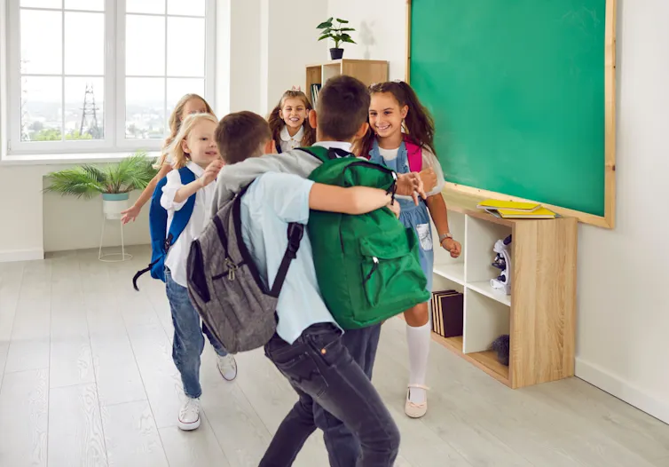Joyeux écoliers s’amusant et jouant en classe à l’école