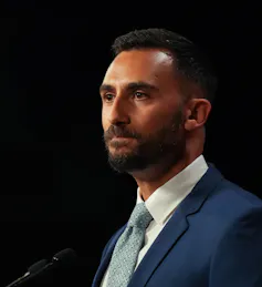 A man in a suit with a white shirt.