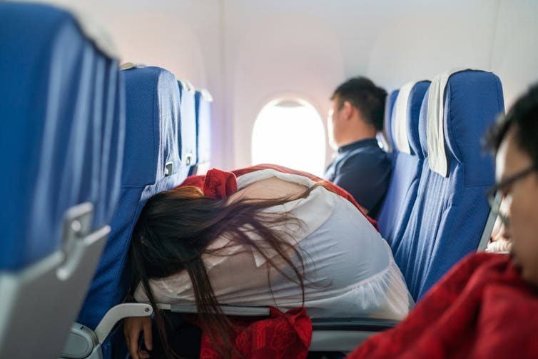 A woman with long hair on an airplane