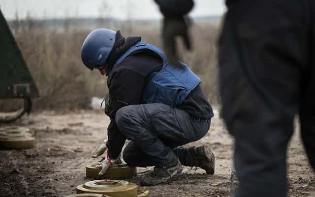 A sapper carefully removes a mine from a field in Ukraine