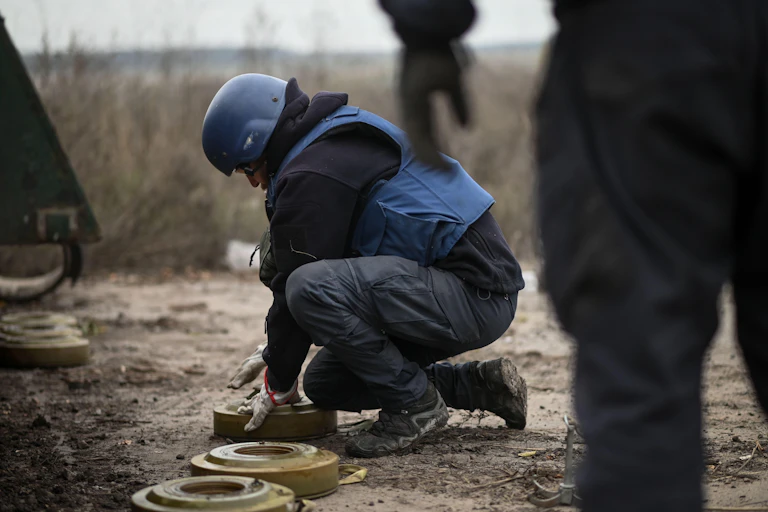 A sapper carefully removes a mine from a field in Ukraine