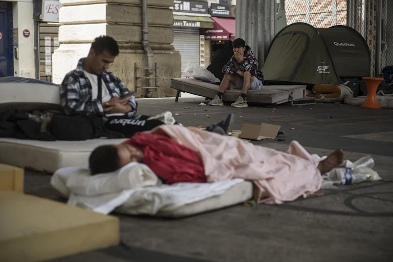 Des hommes assis sur leur matelas dans le camp de migrants du quartier Stalingrad à Paris, le 12 juillet 2023.