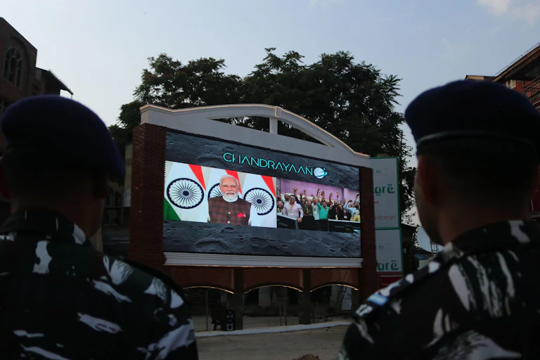 Indian soldiers watch a telecast as Prime Minister Narendra Modi speak after the successful landing of Chandrayaan-3 spacecraft.