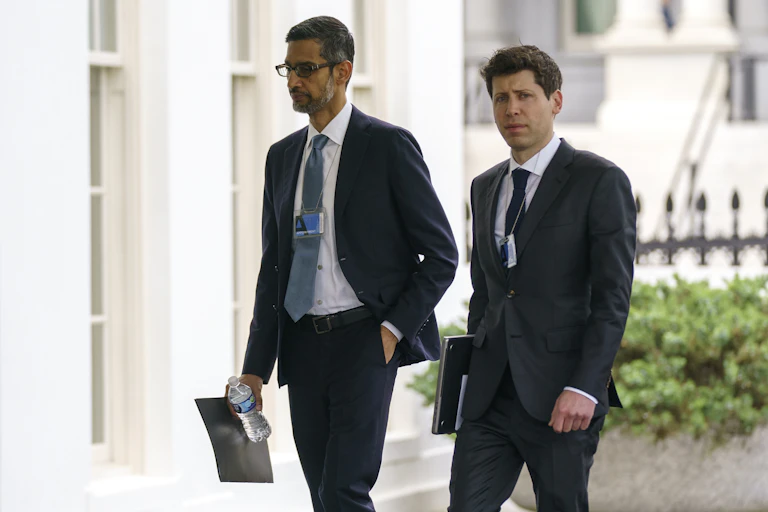 Two men in business suits walk in front of a large building