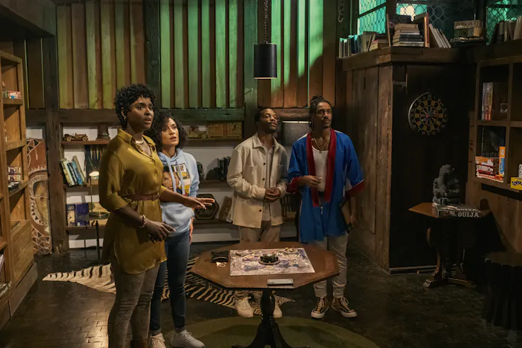 Characters gathered round a board game.
