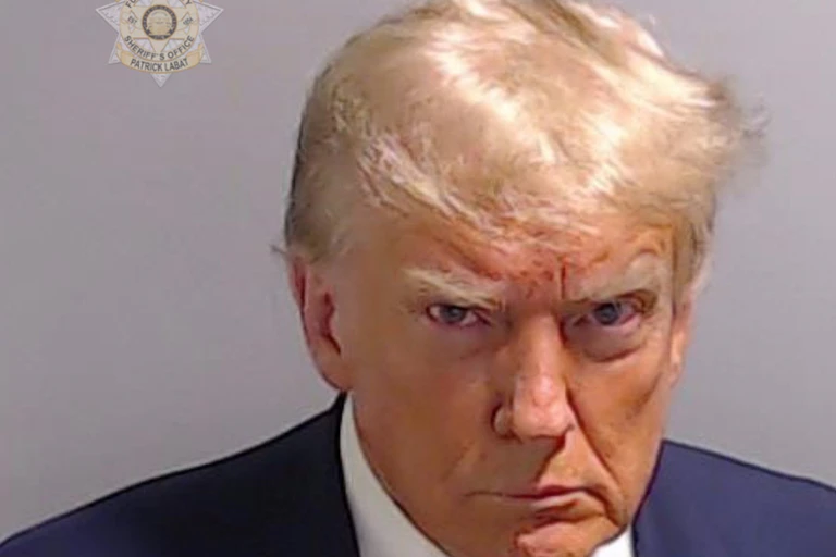 Donald Trump scowls and looks at the camera in a mug shot.