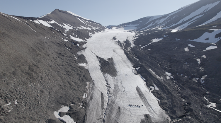 No centro da foto vê-se uma concentração de neve da geleira. Nas laterais, as montanhas estão praticamente sem gelo