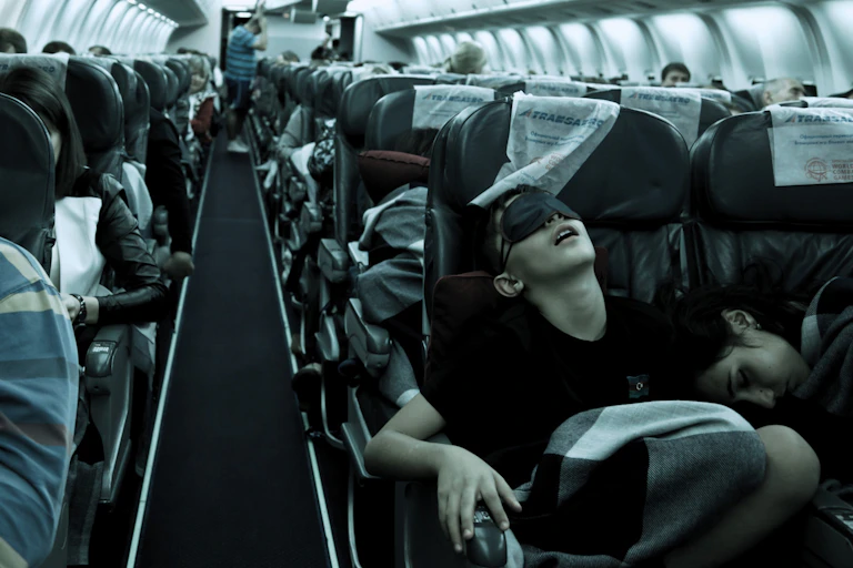 People with sleep masks on a plane with dark surrounds