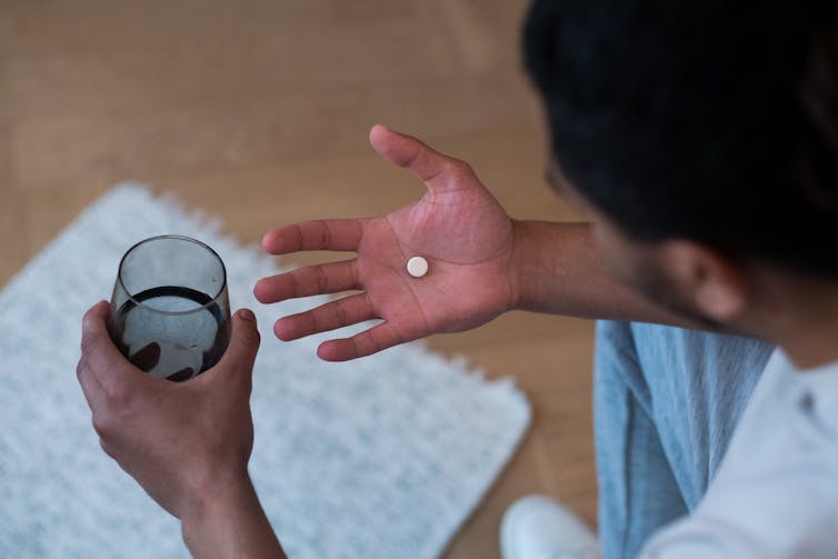 Man looks at pill