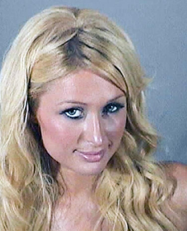 Paris Hilton looks at the camera in a chest-up photograph and wears her long, blonde hair down.