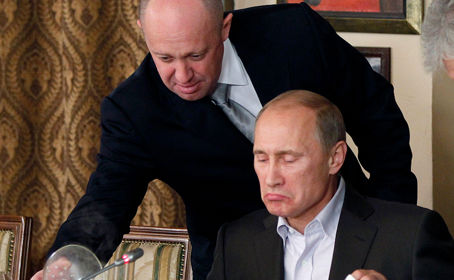 Yevgeny Prigozhin leans over to pour wine for Vladmir Putin