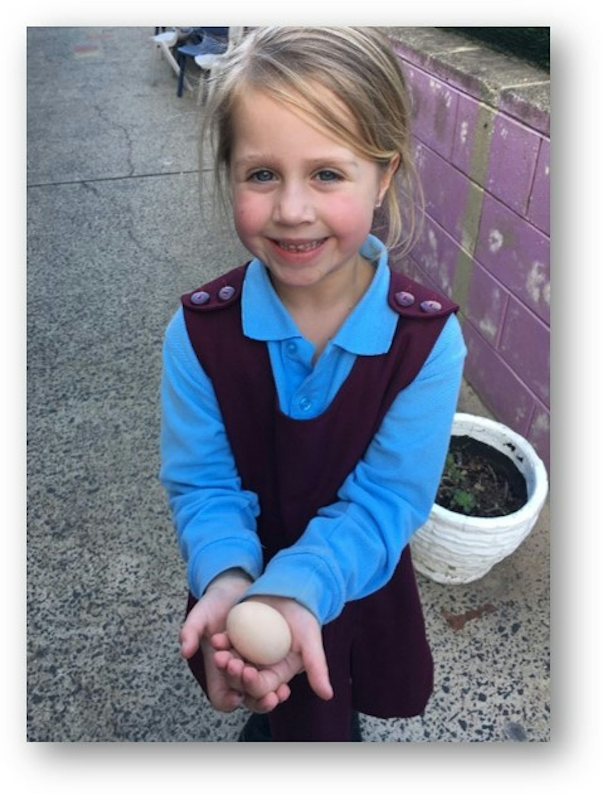A student holds an egg at the after-school chicken coop project.