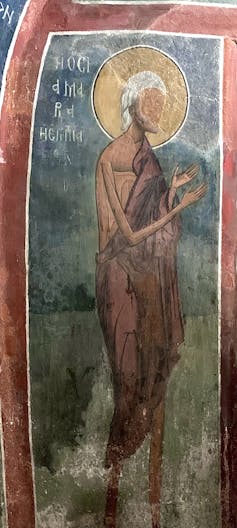 Wall painting of a gaunt woman with a halo.