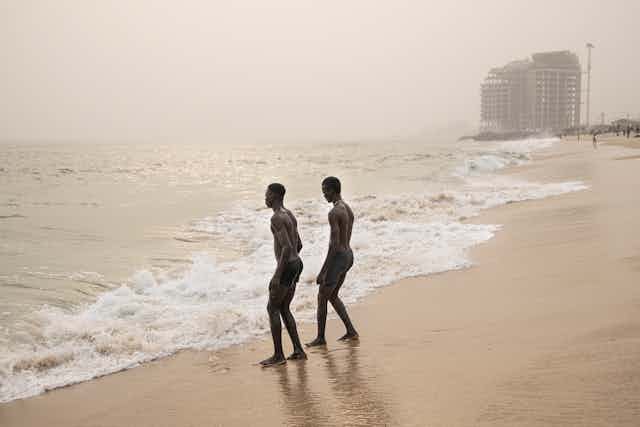 Deux hommes marchent sur une plage