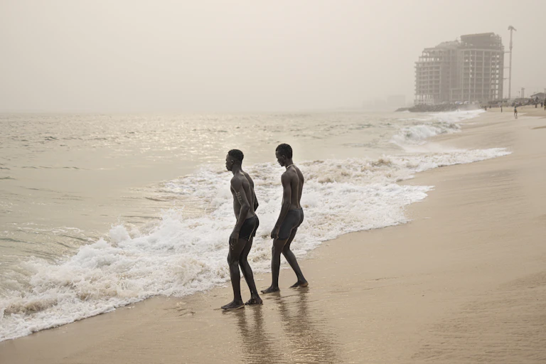Deux hommes marchent sur une plage