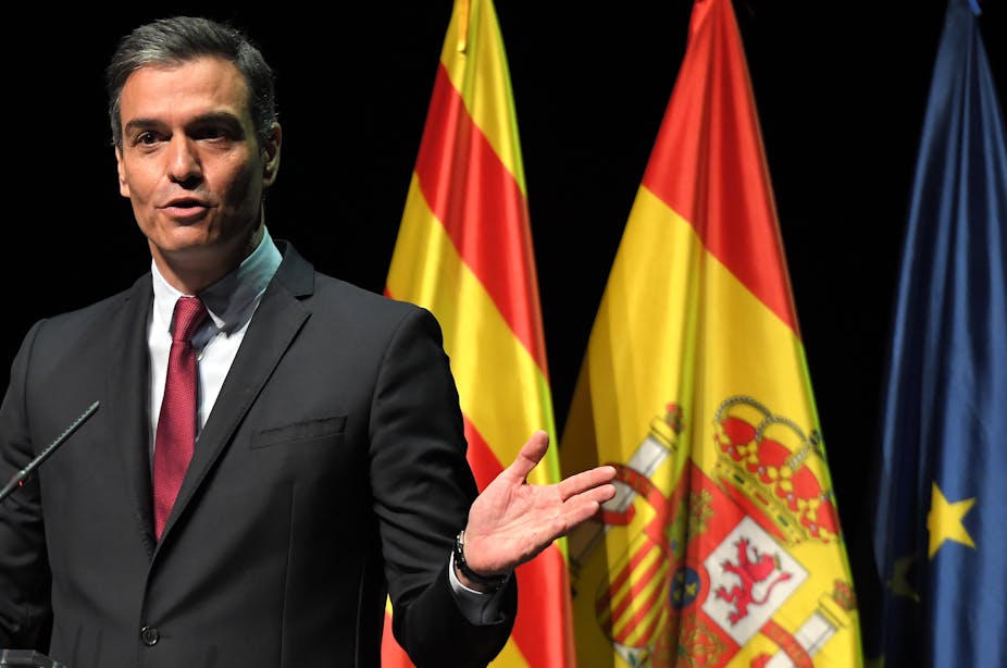 Pedro Sanchez prononce un discours devant les drapeaux catalan, espagnol et européen 
