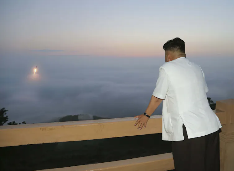 North Korean leader Kim Jong-un watches the launch of a missile from a balcony, 2015.