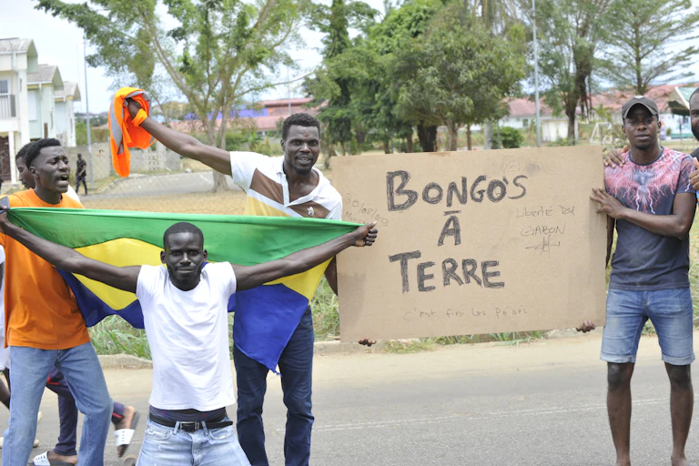 Des hommes arobrant un drapeau et une pancarte