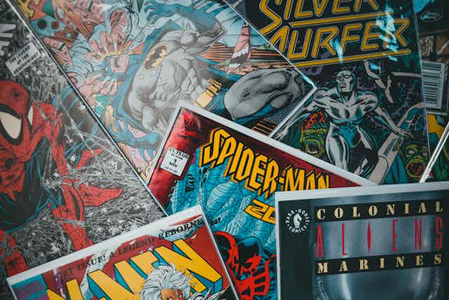 A pile of comic books including Spider-Man and Silver Surfer.