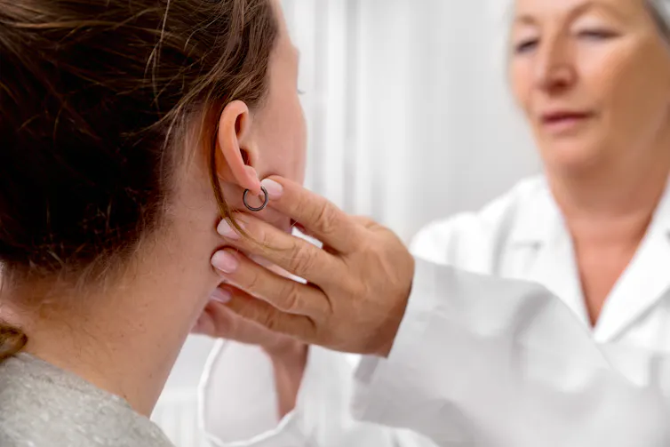 doctor checks patients neck glands
