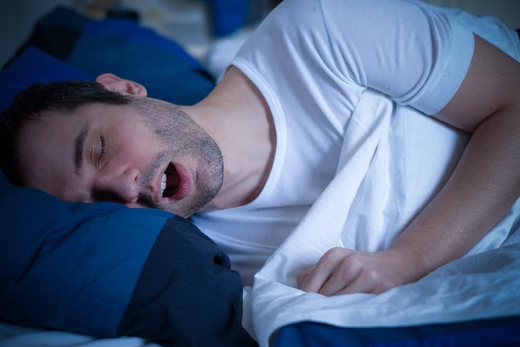 man in bed with mouth open