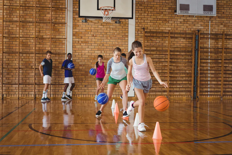 Des élèves s'entraînant au basket dans le gymnase du lycée