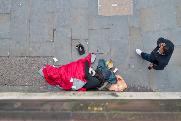 A homeless person on the pavement.