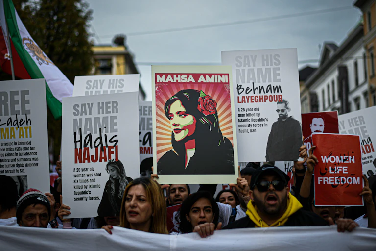 Protesters carrying banners and posters calling for the release or remembrance of Iranian activists