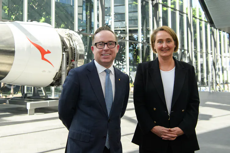 Man and woman standing in front of a plane engine