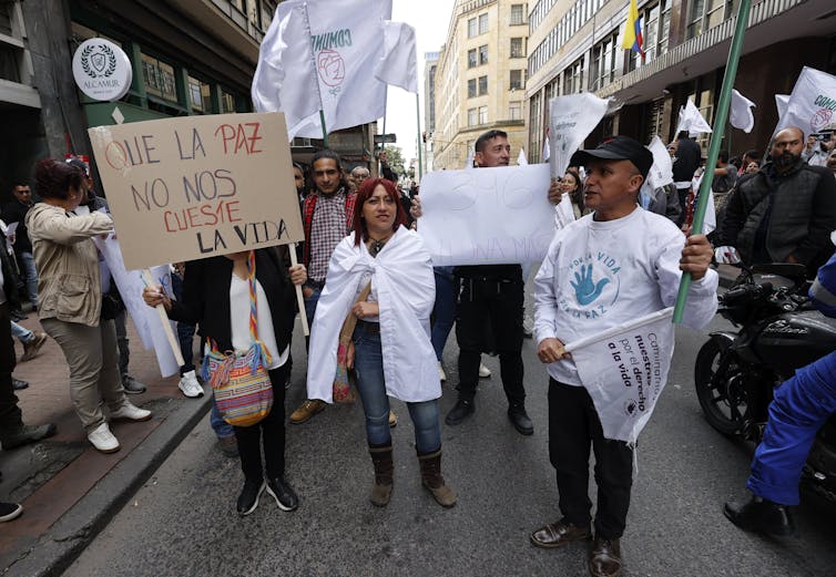 Men and women carrying banners calling for peace march in the streets of Bogota, Colombia, August 2023.