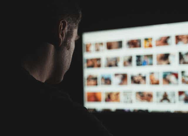 Hombre mirando a pantalla con una web porno.