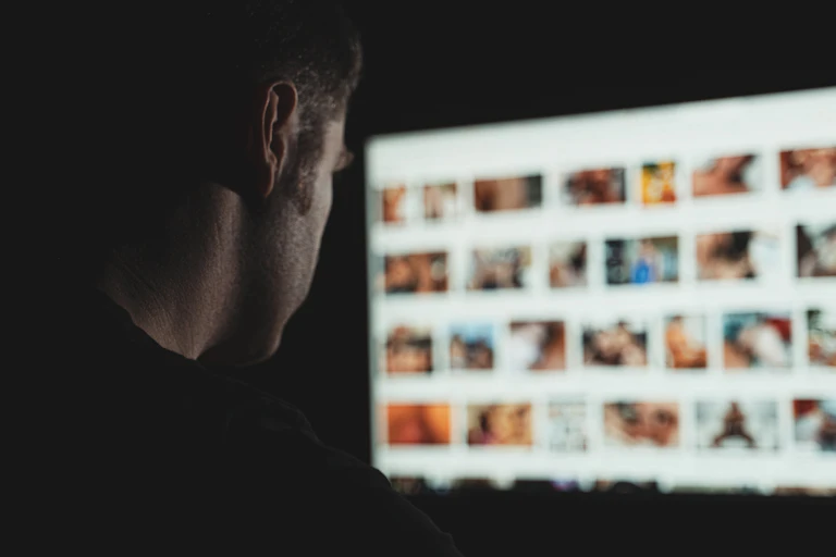 Hombre mirando a pantalla con una web porno.