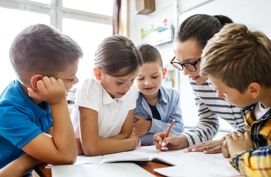Enseignante travaillant avec un groupe d'élèves dans une classe de primaire