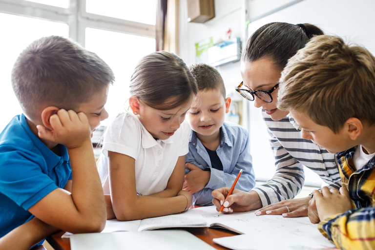 Enseignante travaillant avec un groupe d'élèves dans une classe de primaire