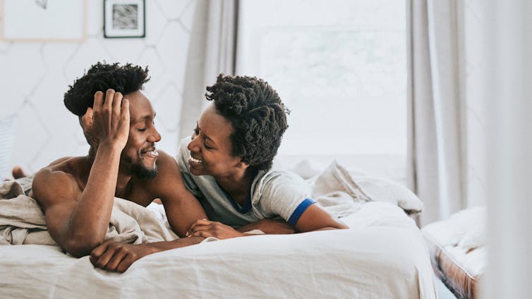 happy black couple playing in bed