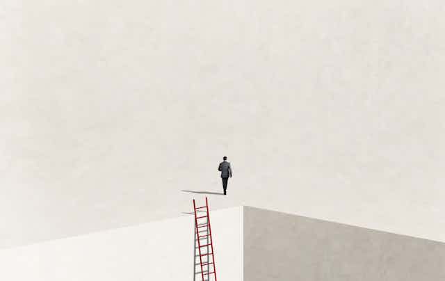 Image of man who has just ascended a ladder walking toward empty space.