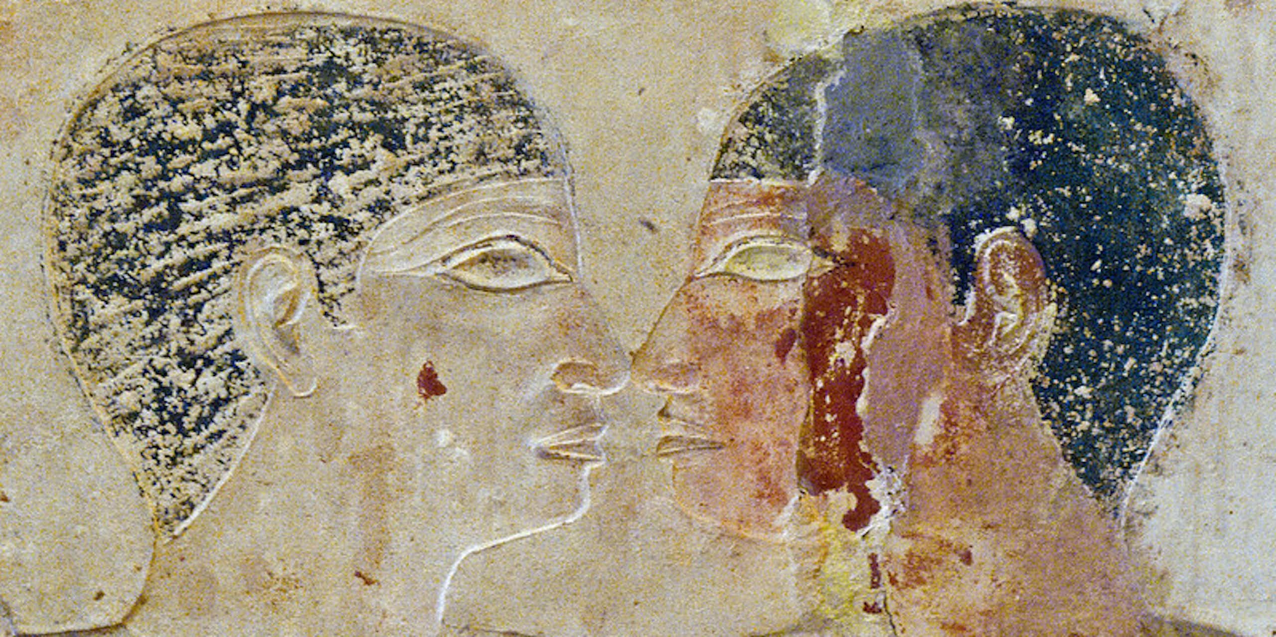 A faded mural depicting two men looking into each other's eyes with their faces very close to each other.