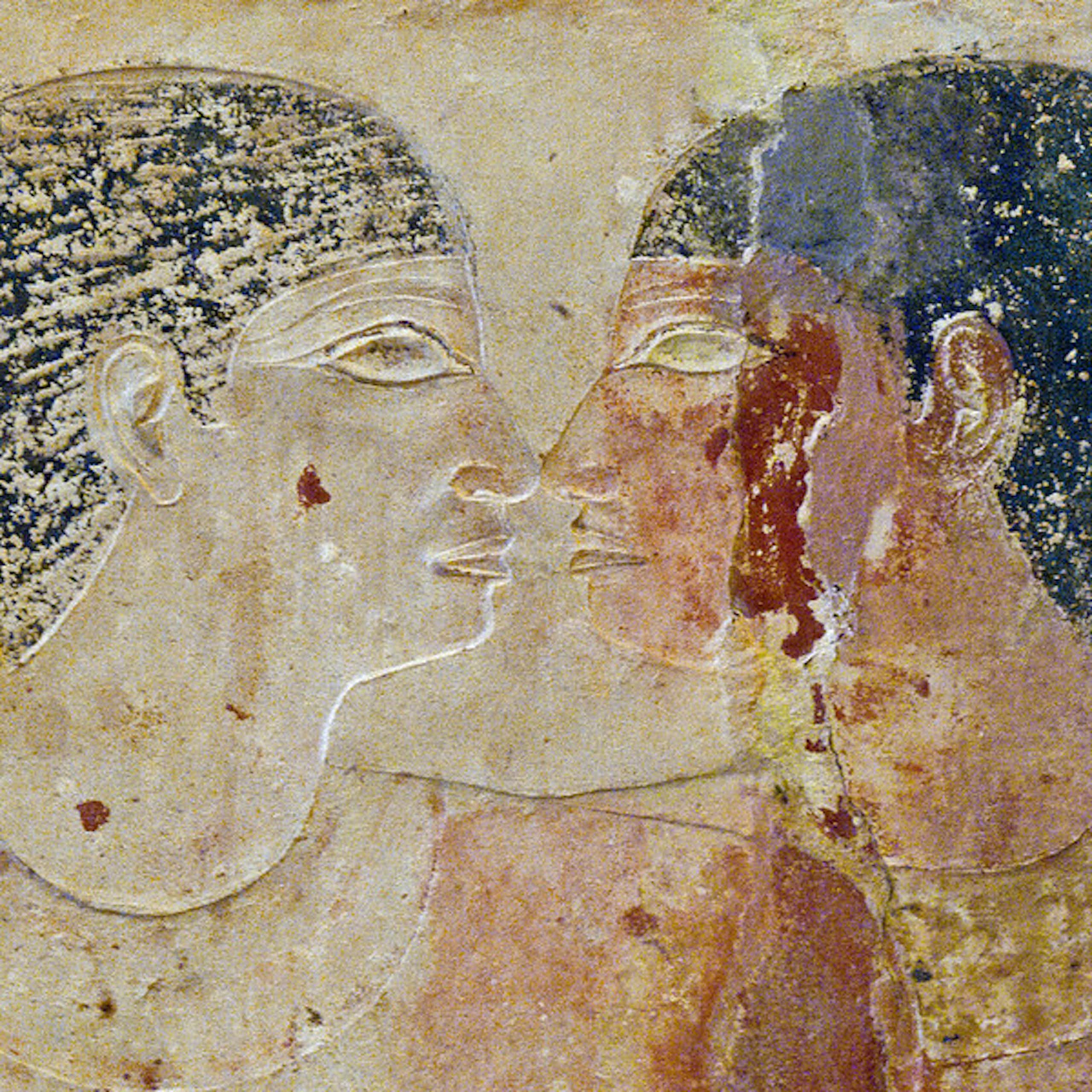 A faded mural depicting two men looking into each other's eyes with their faces very close to each other.