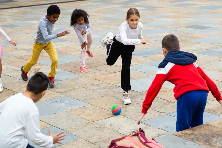 Enfants jouant avec une balle dans une cour de récréation