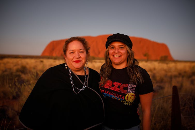 Two women in front of Uluru