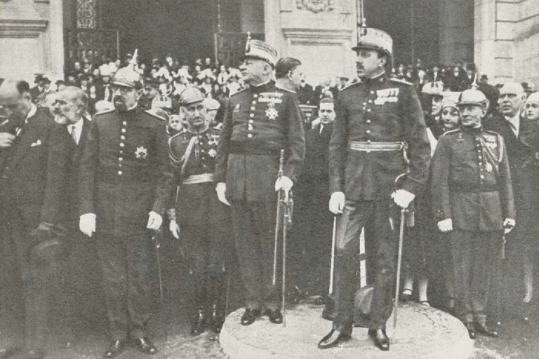 Varios hombres vestidos de militares atienden a algo que sucede fuera del encuadre.
