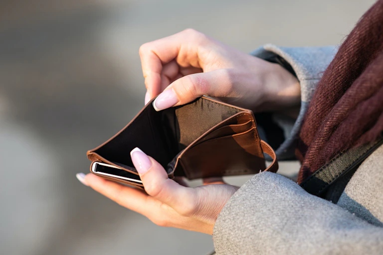 Two hands holding an empty wallet open.