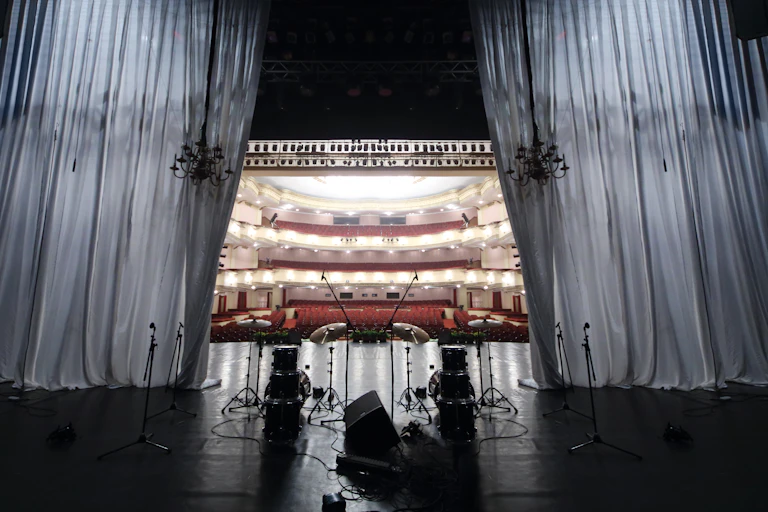 A view of a theatre from the stage, seats are empty.