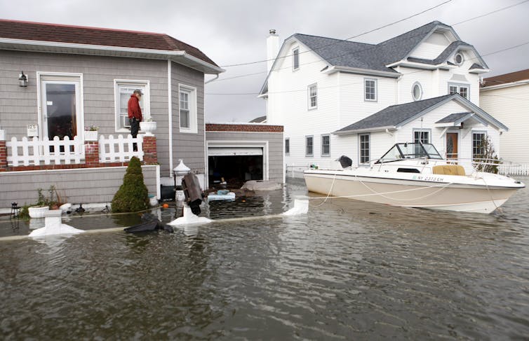 A boat floats in the driveway of a home in the aftermath of Superstorm Sandy.