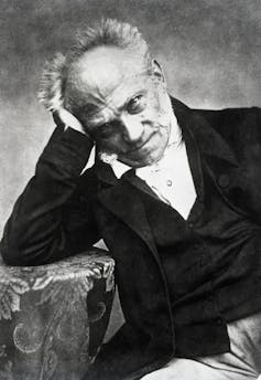 19th-century black-and-white photographic portrait of seated man resting head in hand.
